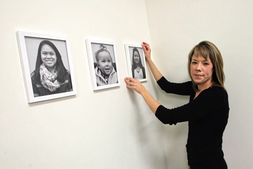 Fallon Gladu is design consultant and is hanging portraits of some of the children who live in the building to help them feel more at home in the common use area at Marie Rose Place 207 Edmonton St a new six-storey building thatÄôs now open and provides supportive housing for immigrant and refugee women. 150205 February 05, 2015 Mike Deal / Winnipeg Free Press