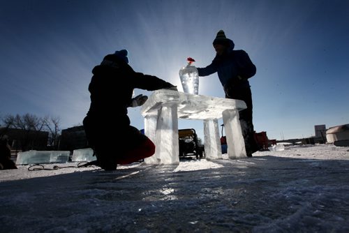 Thomas Jordan, a maintenance worker with the Forks River Trail and Tina Soli an artist from Norway, set a table made of ice on the river trail at the Forks Thursday afternoon.  River Trail crew members made the ice table along with the help of Tina and Luca Soli of Norway with ice harvested from the Red River.    Standup photo.  Feb 04, 2015 Ruth Bonneville / Winnipeg Free Press