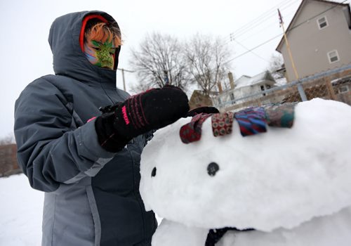 Cezyn Sinclair, 10, decorates a snowman at the West Broadway Snoball, Saturday, February 7, 2015. (TREVOR HAGAN/WINNIPEG FREE PRESS)