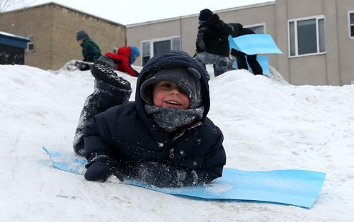 Harrison Brooks, 4, slides down a small snow hill at the West Broadway Snoball, Saturday, February 7, 2015. (TREVOR HAGAN/WINNIPEG FREE PRESS)