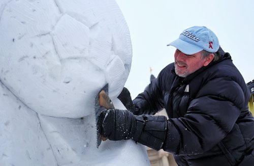 Dave Maddocks puts the finishing touches on a snow-sculpture on the grounds of the Manitoba Legislative Building Monday afternoon. The sculpture marks the 2015 FIFA womenÄôs world cup on one side and the 2015 Grey Cup to be played in Winnipeg on another. FIFA and Grey Cup organizers will help Premier Greg Selinger unveil the snow masterpiece Tuesday morning. 150209 February 09, 2015 Mike Deal / Winnipeg Free Press