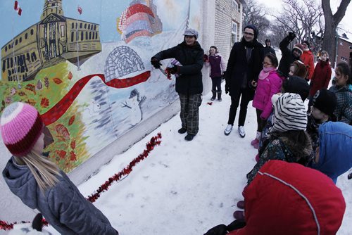 February 9, 2015 - 150209  -  Ildiko Nova cuts a ribbon as Art City participants and their families unveiled the We [heart] Winnipeg mural during a ribbon cutting ceremony at 595 Broadway Monday, February 9, 2015. Eighty young artists and guest artist Ildiko Nova painted the 3-piece mural featuring some of our favourite Winnipeg landmarks (like the Legislative Building, Thunderbird House, the Winnipeg Art Gallery, MTS Centre, and more!), and Manitoba wildlife, through the seasons. John Woods / Winnipeg Free Press