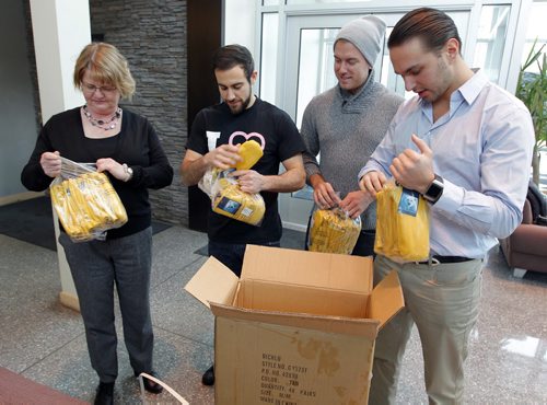 STANDUP - Delivery of new garbage mitts for United Way's Koats for Kids program. (L-R) Donna Albak, program manager for Koats for Kids, Joe Paletta chef and managing partner Carbone Coal Fired Pizza, Michael Nugent fiend of Carbone Coal Fired Pizza that donated 100 pairs of mitts, and Benjamin Nasberg, managing partner at Carbone Coal Fired Pizza. (from UW web) Koats for Kids has been a Winnipeg institution since 1989. Every year, from October to February, the program distributes winter outerwear to families  for some children, having a warm coat means attending school on a cold day, instead of staying home. Its part of United Ways commitment to helping children and youth be all they can be. Photo taken at the United Way office at 580 Main Street. BORIS MINKEVICH / WINNIPEG FREE PRESS  FEB. 10, 2015