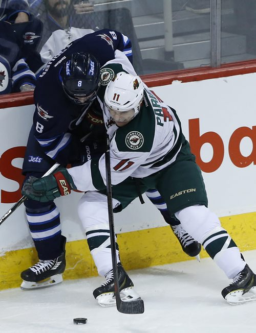 Minnesota Wild's Zach Parise (11) and Winnipeg Jets' Jacob Trouba (8) fight for the puck deep in the Jet's zone during first period NHL action in Winnipeg on Tuesday, February 10, 2015. (John Woods / WINNIPEG FREE PRESS)