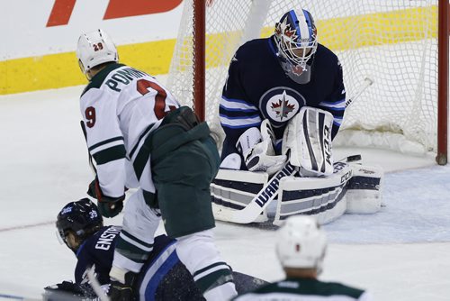Winnipeg Jets goaltender Michael Hutchinson (34) saves the shot from Minnesota Wild's Jason Pominville (29) as Jets' Toby Enstrom (39) defends during first period NHL action in Winnipeg on Tuesday, February 10, 2015. (John Woods / WINNIPEG FREE PRESS)