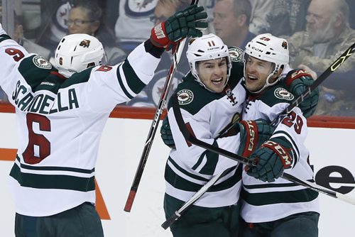 Minnesota Wild's Marco Scandella (6) Zach Parise (11) and Jason Pominville (29) celebrate Pominville's goal against the Winnipeg Jets during third period NHL action in Winnipeg on Tuesday, February 10, 2015. (John Woods / WINNIPEG FREE PRESS)