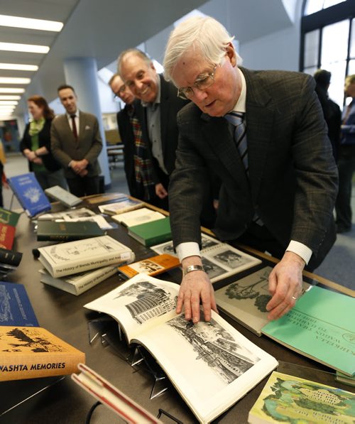 Harry Duckworth, pres. Manitoba Historical Society (MHS) with Minister Ron Lemieux look through "Winnipeg The Gateway to The Golden West" book of photographs published in 1910, one of the donated 27 rare and last copy local history books by the MHS to the Manitoba Legislative Library. These latest additions published between 1910 and 2005 include the history of the  Winnipegosis, Minto, Oakburn and Riverside communities. They will become part of the Local History Collection open to the public in the Legislative Library's reference room at 200 Vaughan St.    Wayne Glowacki/Winnipeg Free Press Feb.11   2015
