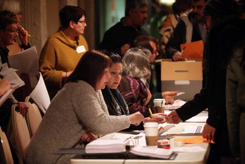 NDP staff members check paperwork as voters file into the Fort Richmond NDP delegate selection committee meeting Thursday.  February 12, 2015 - (Phil Hossack / Winnipeg Free Press)
