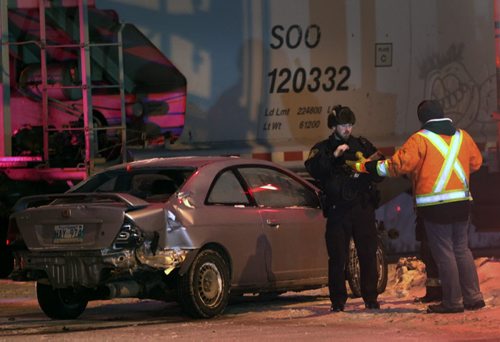 Police investigate a car that ran into a CP Rail train on tracks crossing Bishop Grandin West of Lakewood Blvd Friday morning The driver was not in the car when emergency personnel arrived- Traffic is at a standstill in the area as the train is blocking traffic in both directions on Bishop Grandin Blvd and Fermor Ave-Breaking News- Feb 13, 2015   (JOE BRYKSA / WINNIPEG FREE PRESS)