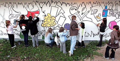 BORIS MINKEVICH / WINNIPEG FREE PRESS  070925 Kids from the Luxton Community Centre paint a mural on the north facing wall of their building. The project started this summer with kids submitting sketches of what the Luxton C.C. meant to their community. Luxton C.C. Art instructor Dorothy Roberts compiled the sketches and painted the outlines on the wall for the kids to fill in with color. It is to be completed by Thursday hopefully. It is also an anti-tagging thing.