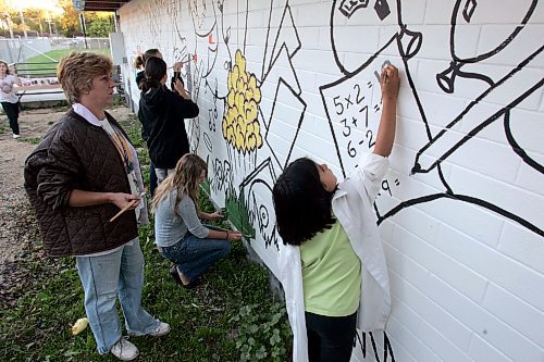 BORIS MINKEVICH / WINNIPEG FREE PRESS  070925 Kids from the Luxton Community Centre paint a mural on the north facing wall of their building. The project started this summer with kids submitting sketches of what the Luxton C.C. meant to their community. Luxton C.C. Art instructor Dorothy Roberts,left, compiled the sketches and painted the outlines on the wall for the kids to fill in with color. It is to be completed by Thursday hopefully. It is also an anti-tagging thing.