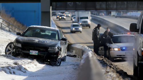 Police and forensic investigators at the scene of a crash along Portage Avenue near the Empress Street underpass, Saturday, February 14, 2015. (TREVOR HAGAN/WINNIPEG FREE PRESS)