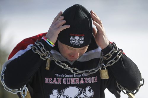 Escape artist, Dean Gunnarson is secured into locks and chains before performing an escape between two zamboni's on the Red River near The Forks, Saturday, February 14, 2015. (TREVOR HAGAN/WINNIPEG FREE PRESS)