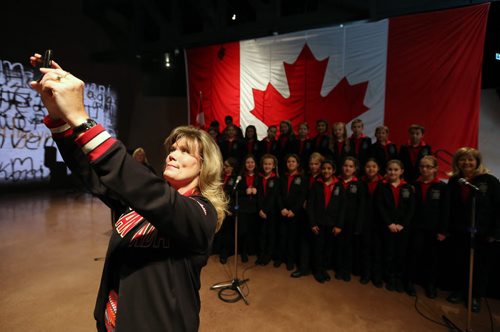 Minister Shelly Glover takes a selfie with the Winnipeg Youth Choir after they performed "Oh Canada" during a flag raising event at the CMHR on the 50th anniversary of our current Canadian Flag, Sunday, February 15, 2015. (TREVOR HAGAN/WINNIPEG FREE PRESS)