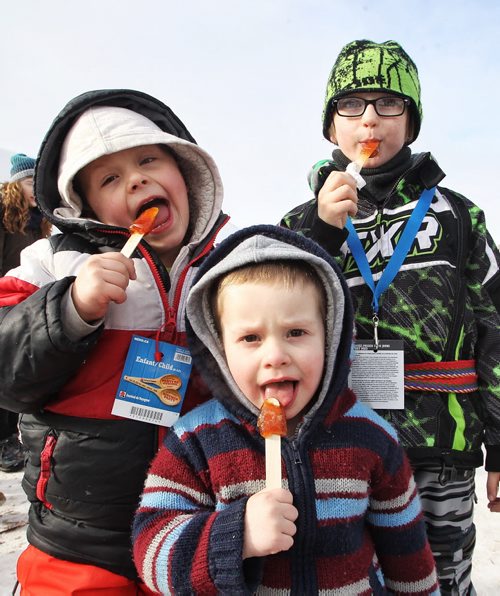 (Front to back) Grayson Lindsay, 2, Cole Lindsay, 6, and Paul Gill, 7, enjoy Maple Syrup on a Stick while at the Festival du Voyageur Monday afternoon on Louis Riel Day.  150216 February 16, 2015 Mike Deal / Winnipeg Free Press