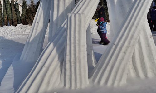 People walk past the snow sculptures on the grounds of the Festival du Voyageur on Monday, Louis Riel Day.  150216 February 16, 2015 Mike Deal / Winnipeg Free Press