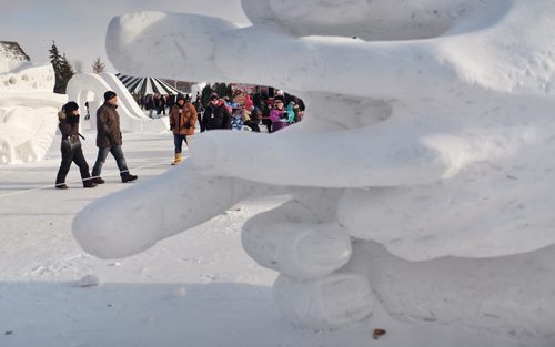 People walk past the snow sculptures on the grounds of the Festival du Voyageur on Monday, Louis Riel Day.  150216 February 16, 2015 Mike Deal / Winnipeg Free Press