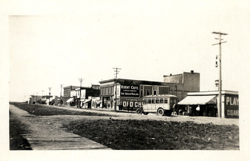 Canstar Community News Regent St. looking west. Wooden sidewalks on both north and south sides of Regent. Queens Court, billiards, Apollo Theatre, Toney's Cafe, billiard and meat market, and Royal George Hotel in view. (TRANSCONA HISTORICAL MUSEUM).
