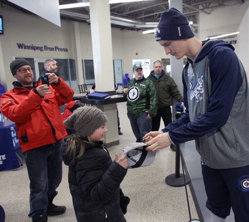 Winnipeg Jets Tyler Myers signs an autograph for 10 yr old Cleo Wermann Thorn as her dad Duane Thorn snaps a shot before practice at the MTS Iceplex Wednesday Standup Photo- Feb 18, 2015   (JOE BRYKSA / WINNIPEG FREE PRESS)