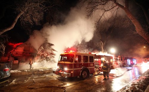 Weary firefighters battle a blaze in the 600 block of Elgin just east of Sherbrook Wednesday night. One house (617) was totally destroyed another damage 615). Extreme cold hampered efforts exhausting the firefighters and coating them and everything else in ice. February 18, 2015 - (Phil Hossack / Winnipeg Free Press)