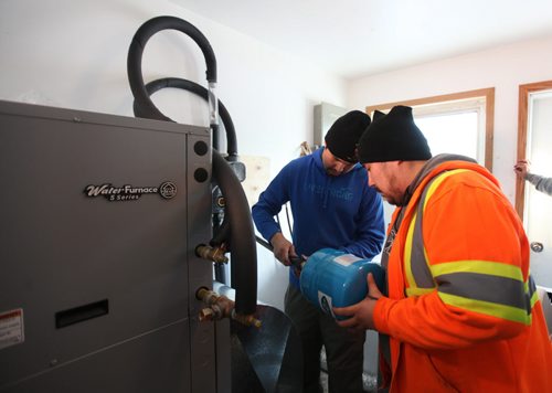 Lyle McKay (blue) and  Clayton Sinclair (orange) trained service technicians from the community install a geothermal furnace into a older home in the community.  Not only has the renewable energy source drastically cut residents heating bills but also has provided training and employment for residents.  Feature story on how sustainable energy sources like  geothermal and solar are being implemented on First Nation reserves like Peguis and Fisher River and its positive impact on the people and our province.   See Alex Paul story.   Feb 17, 2015 Ruth Bonneville / Winnipeg Free Press