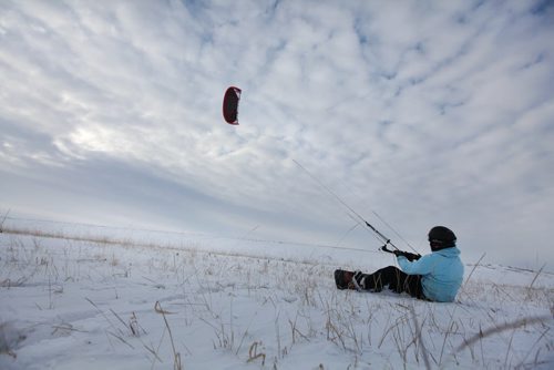 Carlos Abodu takes a short break while waiting for the wind to fill his kite while kite boarding across the snow and into the air in the fields along Kenaston Blvd Thursday. Standup photo Feb 19, 2015 Ruth Bonneville / Winnipeg Free Press