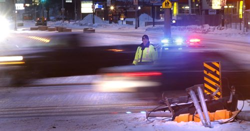 Motorists should take caution on the streets Friday morning after a light overnight snow fall. Winnipeg Police were out directing traffic on Henderson Hwy. at Chief Peguis Trail after a traffic light was taken down.   Wayne Glowacki/Winnipeg Free Press Feb.20   2015