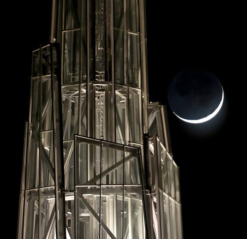 Barely a sliver of the moon is visible as it rises behind the Canadian Museum for Human Rights, Friday, February 20, 2015. (TREVOR HAGAN/WINNIPEG FREE PRESS)