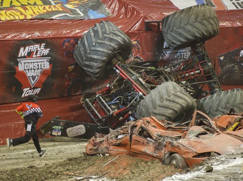 DAVID LIPNOWSKI / WINNIPEG FREE PRESS (Saturday February 21, 2015)  A crew member runs to check on driver Cory Rummell after he crashed monster truck Spike during Maple Leaf Monster Jam Saturday afternoon at the MTS Centre.