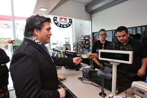 Tim Daniels the Economic Development Officer for Long Plain FN buys a pack of cigarettes after giving his treaty number after the grand opening of  the new Petro Canada gas station on Madison Street, Winnipeg's first urban reserve gas station.  150223 February 23, 2015 Mike Deal / Winnipeg Free Press