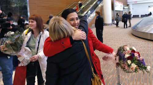 Three members of Team Jones, second Jill Officer is hugged and lead Dawn McEwen at left and  alternate Jennifer Clark-Rouire  arrived at James A Richardson International Airport Monday after the team won the Canadian championship in the Scotties Tournament of Hearts Sunday. Wayne Glowacki/Winnipeg Free Press Feb.23   2015