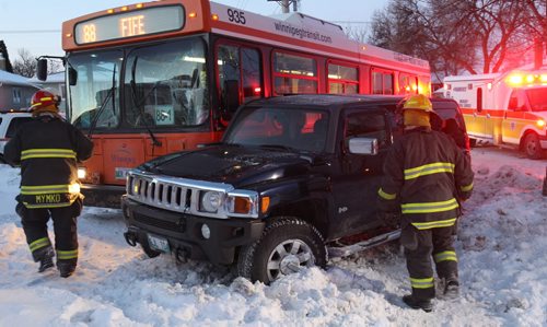 A Winnipeg Transit bus and a hummer collided this morning at the corner of Airles and Polson St.- The mishap ended up on the front yard of a home at the intersection_ 1 person was seen being loaded into a ambulance with injuries  Standup Photo- Feb 24, 2015   (JOE BRYKSA / WINNIPEG FREE PRESS)