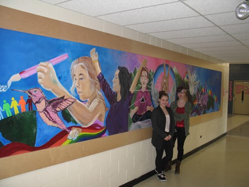 Canstar Community News Feb. 18, 2015 - Grade 10 River East Collegiate students Britney Kowalchuk-Corrigal, 15, and Sam Erociuk, 15, stand before a new mural on the theme of "peace" their art class collaborated to paint. (SHELDON BIRNIE/CANSTAR COMMUNITY NEWS/HERALD).