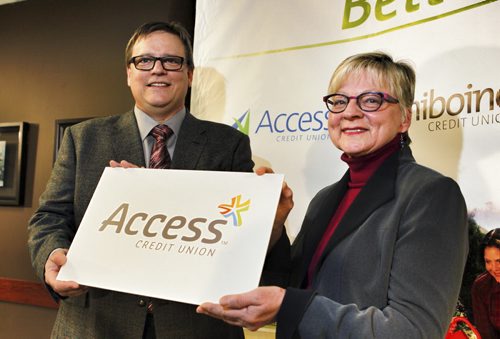 BIZ - Access Credit Union - (left to right) Darryl Loewen, board chair Access Credit Union, and Margaret Day, Assiniboine Credit Union pose for a photo with the new logo after a press conference announcing the the merger of the banks. February 25, 2015 (Boris Minkevich/Winnipeg Free Press)