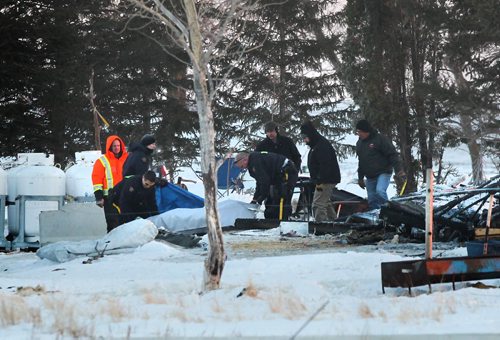 Firefighters and RCMP officers prepare to remove the body of one of the deceased children that died in a house fire that totally demolished the 2-storey home in the RM of Morris Manitoba early Wednesday morning and took the lives of four children.  See story.  Feb 25, 2015 Ruth Bonneville / Winnipeg Free Press