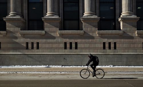 A cyclist rides by the facade of the A. A. Heaps Building (254 Portage Avenue) on Garry Street as the temperature hovers around -20C Thursday morning.  150226 February 26, 2015 Mike Deal / Winnipeg Free Press