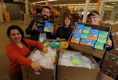 NEWS - Harvest has received 20 banana boxes full of menstrual product donations as the result of Mondays Free Press column, which inspired a QX104 campaign. Left to right- International volunteer Rosa Martinez, Winnipeg Harvest communications/marketing associate Jason Booth, volunteer Lauren Rist, and Winnipeg Harvest development associate signature events Duncan Stokes. The group posed for a photo with some of the 20 boxes of donated products. WINNIPEG HARVEST STORY.  BORIS MINKEVICH/WINNIPEG FREE PRESS FEB. 27, 2015