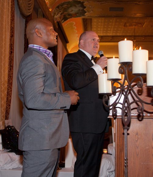 Former Winnipeg Blue Bombers star Charles Roberts gives Free Press sports columnist Gary Lawless a little help with an auction prize at the Mood Disorders Association of Manitobas annual In the Mood gala at the Fort Garry Hotel on Feb. 21, 2015. The event honours individuals who have helped raise awareness about mental-health issues. (JOHN JOHNSTON / WINNIPEG FREE PRESS)