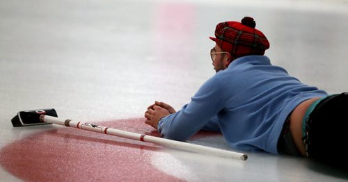 Jordon Ottenson, from Yes We Missed It, laying on the ice watching his shot during the Manitoba Music Rocks Charity Bonspiel at the Granite Curling Club, Saturday, February 28, 2015. (TREVOR HAGAN/WINNIPEG FREE PRESS)