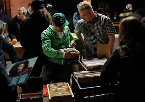 Vendors Steve St. Louis (left) shows Grant Davis (right) how to use a portable player for a customer as a steady stream of vinyl lovers browse through the offerings at the Central City Record Show at Union Sound Hall Sunday afternoon.  150301 March 01, 2015 Mike Deal / Winnipeg Free Press