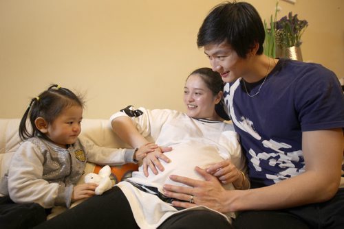 Liang Xing RWB principal male  with his 2 yr old  daughter Vivian Xing  and his expecting wife Ke Hu in his Winnipeg home See Tait,Bryksa,Zoratti feature - Feb, 2015   (JOE BRYKSA / WINNIPEG FREE PRESS)