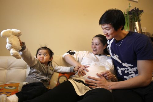 Liang Xing RWB principal male  with his 2 yr old  daughter Vivian Xing  and his expecting wife Ke Hu  in his Winnipeg home See Tait,Bryksa,Zoratti feature - Feb, 2015   (JOE BRYKSA / WINNIPEG FREE PRESS)