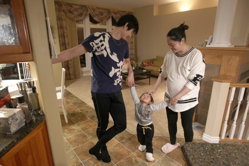 Liang Xing RWB principal male  with his 2 yr old daughter Vivian Xing  and his expecting wife Ke Hu in his Winnipeg home See Tait,Bryksa,Zoratti feature - Feb, 2015   (JOE BRYKSA / WINNIPEG FREE PRESS)