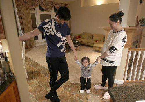 Liang Xing RWB principal male  with his daughter , 2 yr  Vivian Xing and his expecting wife Ke Hu in his Winnipeg home See Tait,Bryksa,Zoratti feature - Feb, 2015   (JOE BRYKSA / WINNIPEG FREE PRESS)