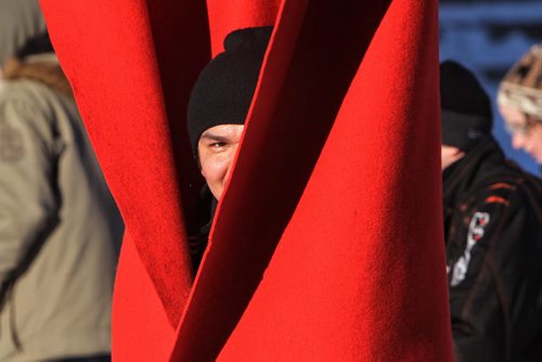 Dustin Apetagon wraps himself up for a quick warmup in one of the hanging blankets on the River Trail at The Forks Sunday afternoon.   150301 March 01, 2015 Mike Deal / Winnipeg Free Press