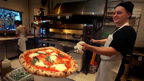 Pizza cook at Vera's Pizzeria Sean Divids shows off a margherita pizza Monday evening at the Riverview area restraunt. See Marion's story. March,2 2015 - (Phil Hossack / Winnipeg Free Press)