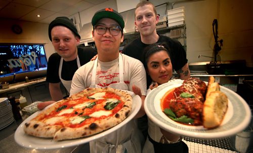 Left to right, Sean Divids, Terik Cabildo (owner/chef), Alex Murray and Edelma Miranda show off margherita pizza and Meatballs polpette Monday evening at the Riverview area Vera Pizzeria. See Marion's story. March,2 2015 - (Phil Hossack / Winnipeg Free Press)