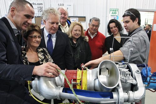 Drew Tapley (right) a CNC Instructor shows a scale model of a Rolls Royce C18 engine to (l-r) MLA Kevin Chief, Marileen Bartlett executive director at the Centre for Aboriginal Human Resource Development Inc., Jean Charest former Canadian heritage minister, Wayne Helgason board member, Dorothy Dobbie former MP, Bill Shead chair of the board, and Tanis Wheeler board member, during a tour of the Neeginan Centre (formerly the Aboriginal Centre of Winnipeg).  150304 March 04, 2015 Mike Deal / Winnipeg Free Press