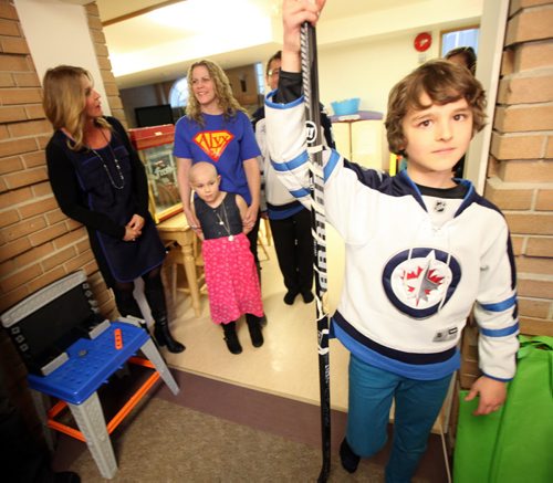 Keaton Hamin (9), holds up an autographed stick given to him Wednesday by TJ Stroud. TJ offered to replace a stick Keaton won then gave to leukemia patient, Alyx Delaloye (7)  (standing rear with her mom Jody) .  Allison Kesler CEO of Ronald MacDonald House Mb.stands left. See Ashley Prest story. Maarch 4, 2015 - (Phil Hossack / Winnipeg Free Press)