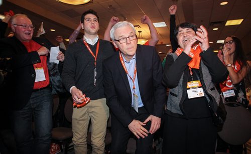 Greg Selinger with a look of relief stands up while his wife Claudette Toupin (right) celebrates his re-election as the leader of the provincial NDP on sunday at the NDP Convention at Canad Inns Polo Park. 150308 - Sunday, March 08, 2015 -  (MIKE DEAL / WINNIPEG FREE PRESS)